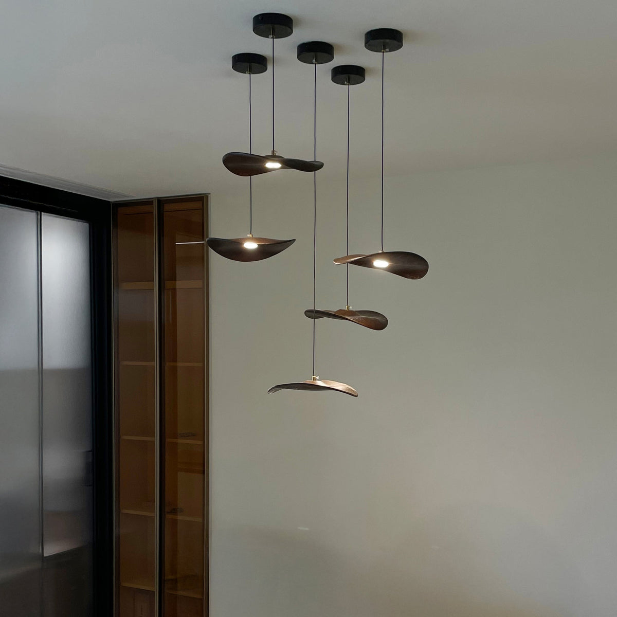 Wellenförmige Pendelleuchte aus Holz mit Blattmotiv